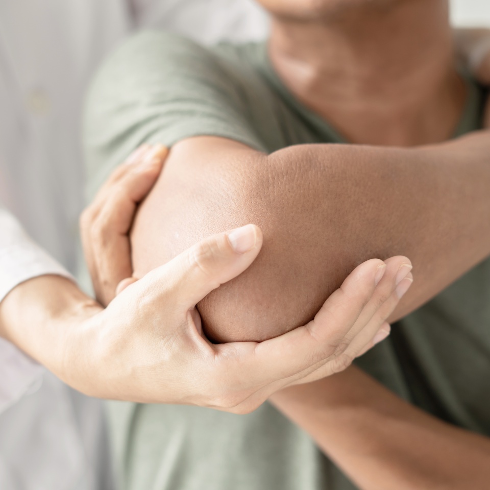 Female physiotherapists provide assistance to male patients with elbow injuries examine patients in rehabilitation centers. Physiotherapy concepts.