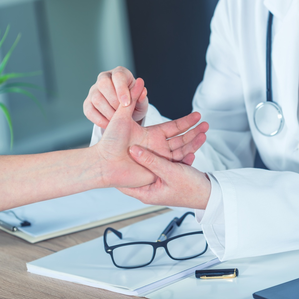 Female patient at orthopedic medical exam in doctor's hospital office, traumatology and medical consultation for hand wrist injury