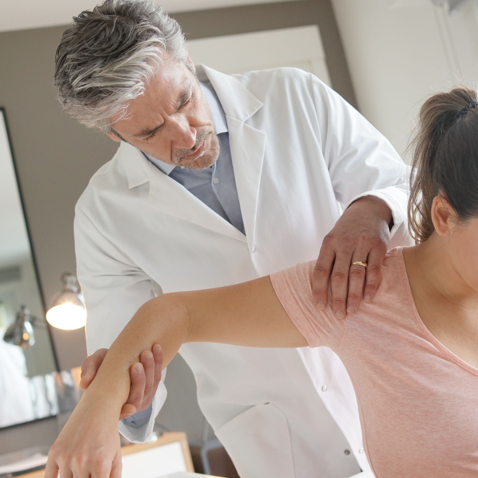 Physiotherapist helping patient with shoulder injury