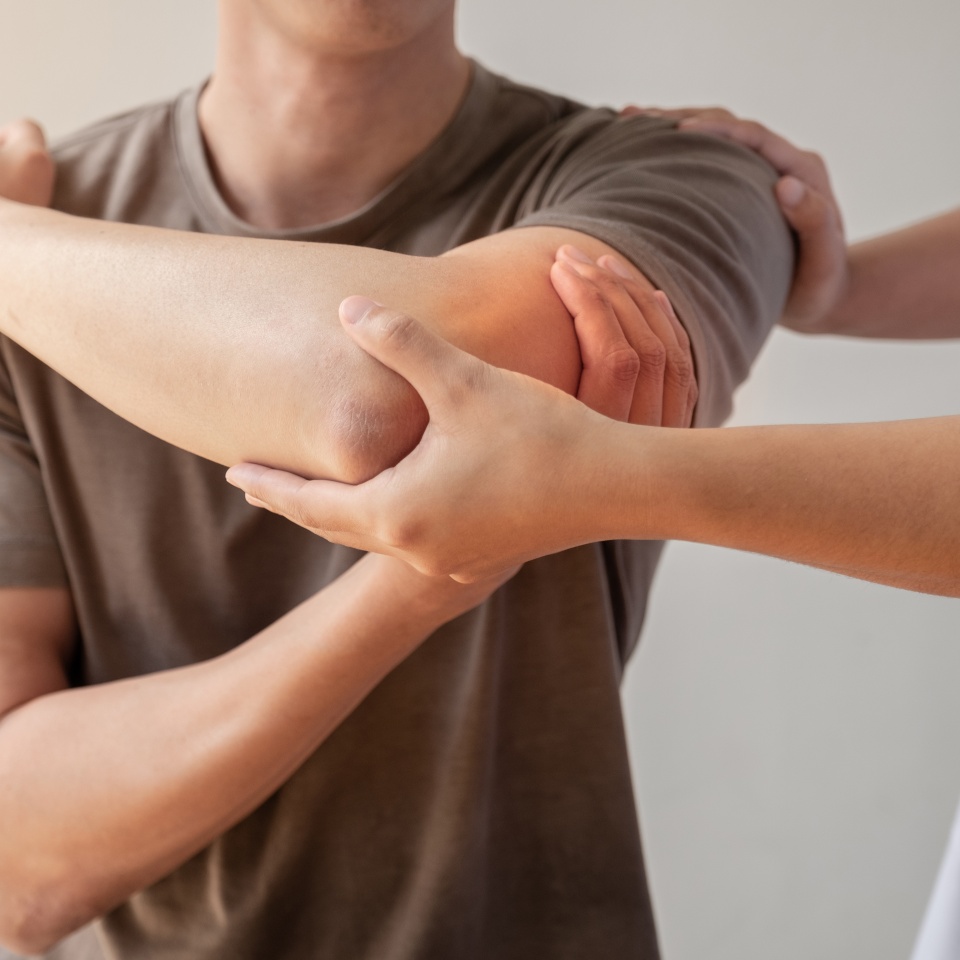 Female physiotherapists provide assistance to male patients with elbow injuries examine patients in rehabilitation centers. Physiotherapy concepts.