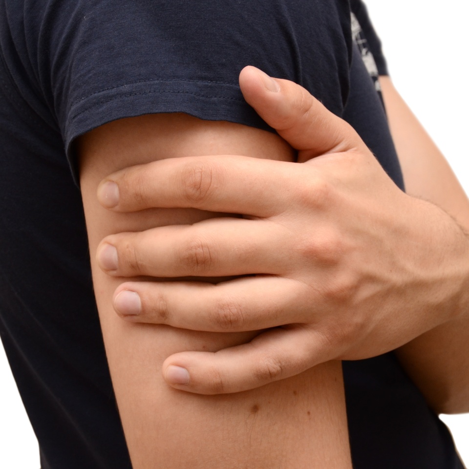 Pain in the forearm of a young man, holding his hand to a sore spot. Horizontal photo isolated, medicine concept.