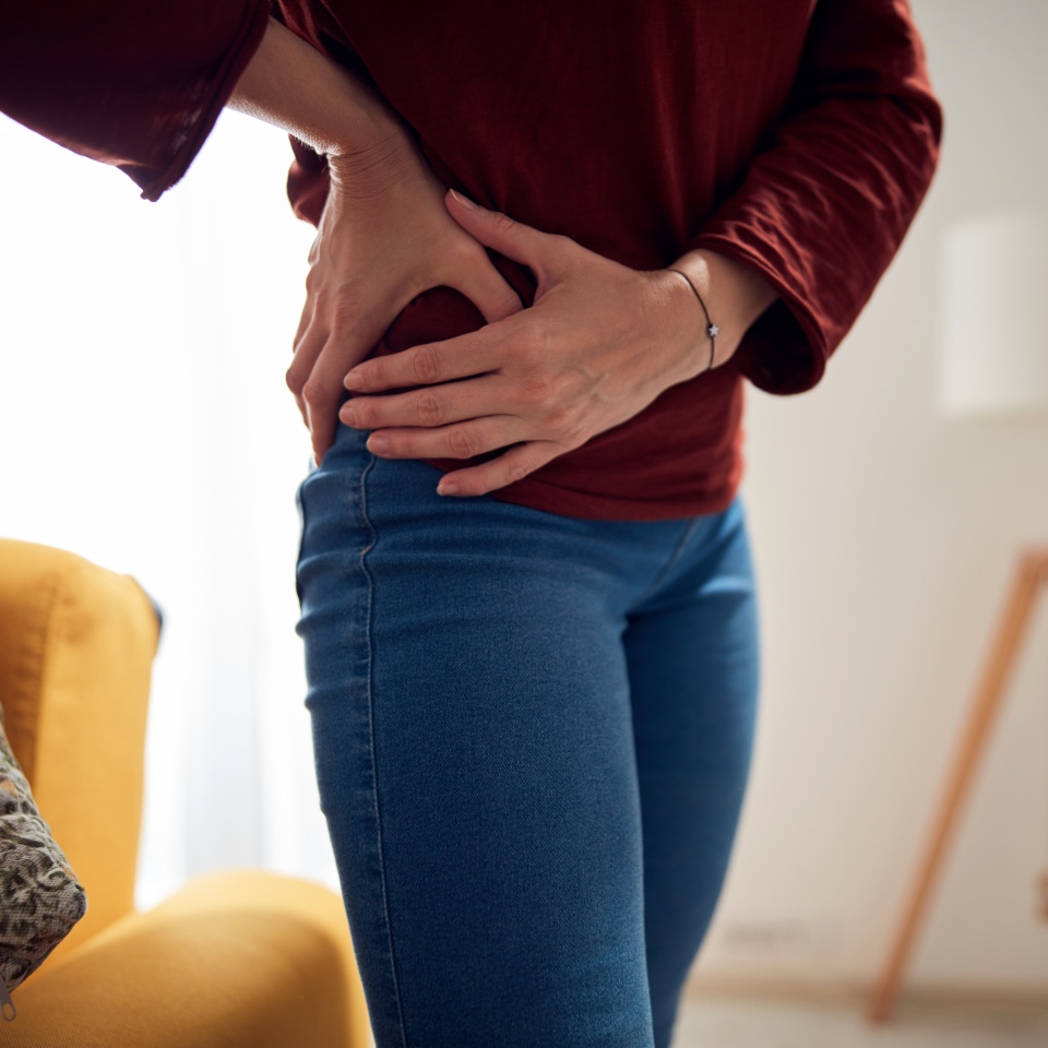 Woman with strong hip pain at home.