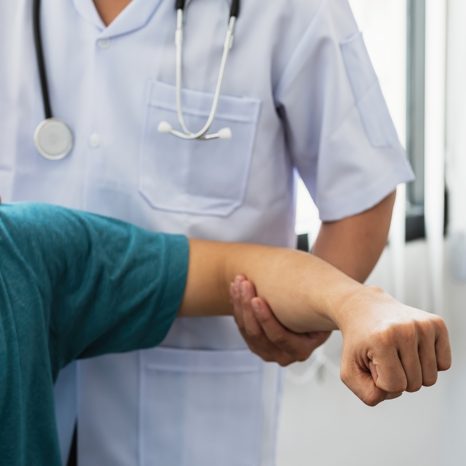 Close-up of a physiotherapist stretching to a man patient at the clinic.