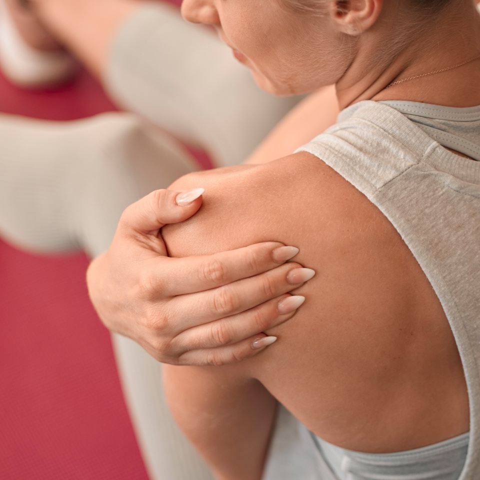 Shoulder injury, woman and pain in gym from exercise, medical emergency and injured muscle, problem and above. Closeup female, arm and sports accident from workout, first aid and fitness health risk.