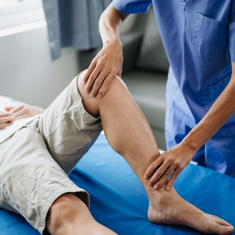 Close up of Physiotherapist working with patient on the bed in clinic