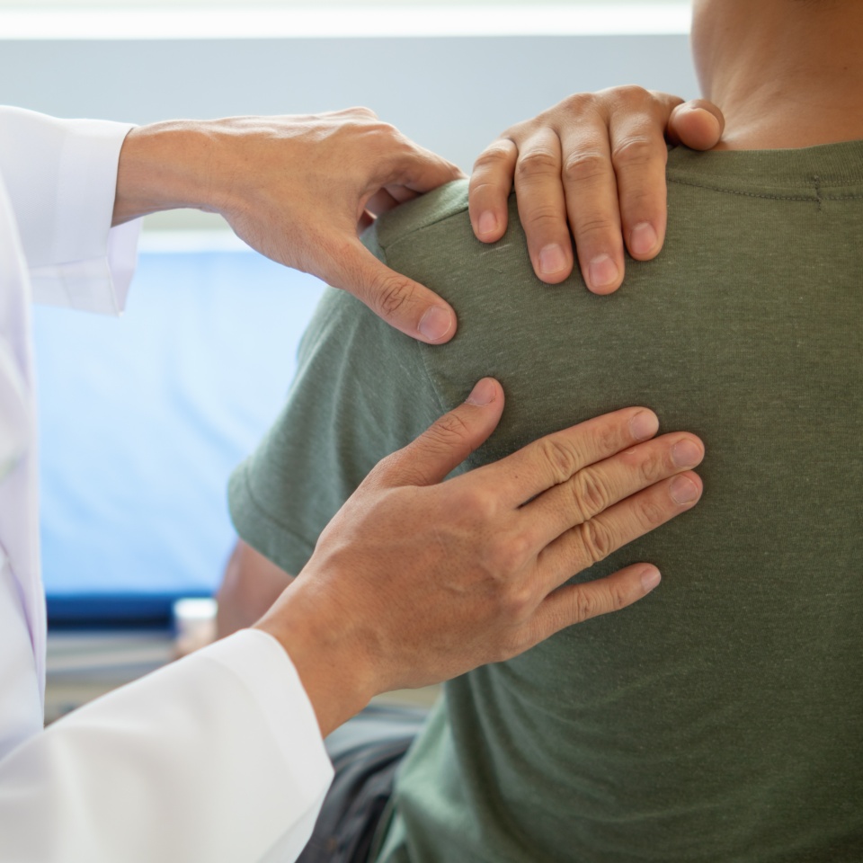man was admitted for treatment of muscle pain in back of his shoulder due to working hard and causing muscle inflammation. doctor is treating man muscle pain in his back and shoulders due to overwork.