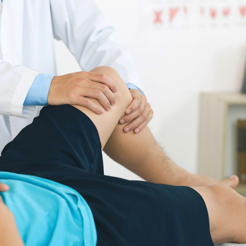 physiotherapist massaging the knee of a patient. rehabilitation and recovery after physical knee injuries.Rehabilitation physiotherapy. Sportsman Recovering from Injury, Undergoing Rehabilitation.
