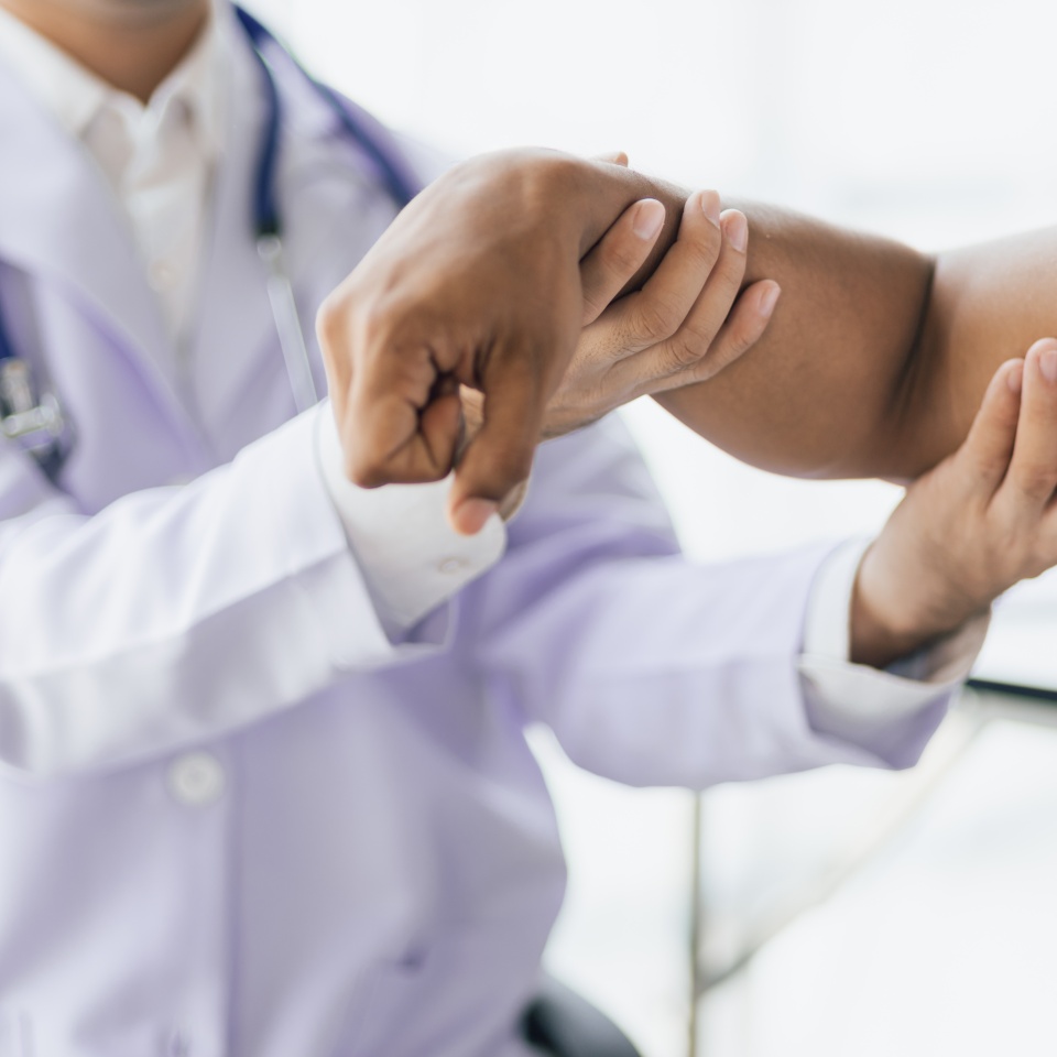 Man with arm pain, wrist pain and shoulder pain is seeing a doctor for diagnosis in an examination room at a hospital.