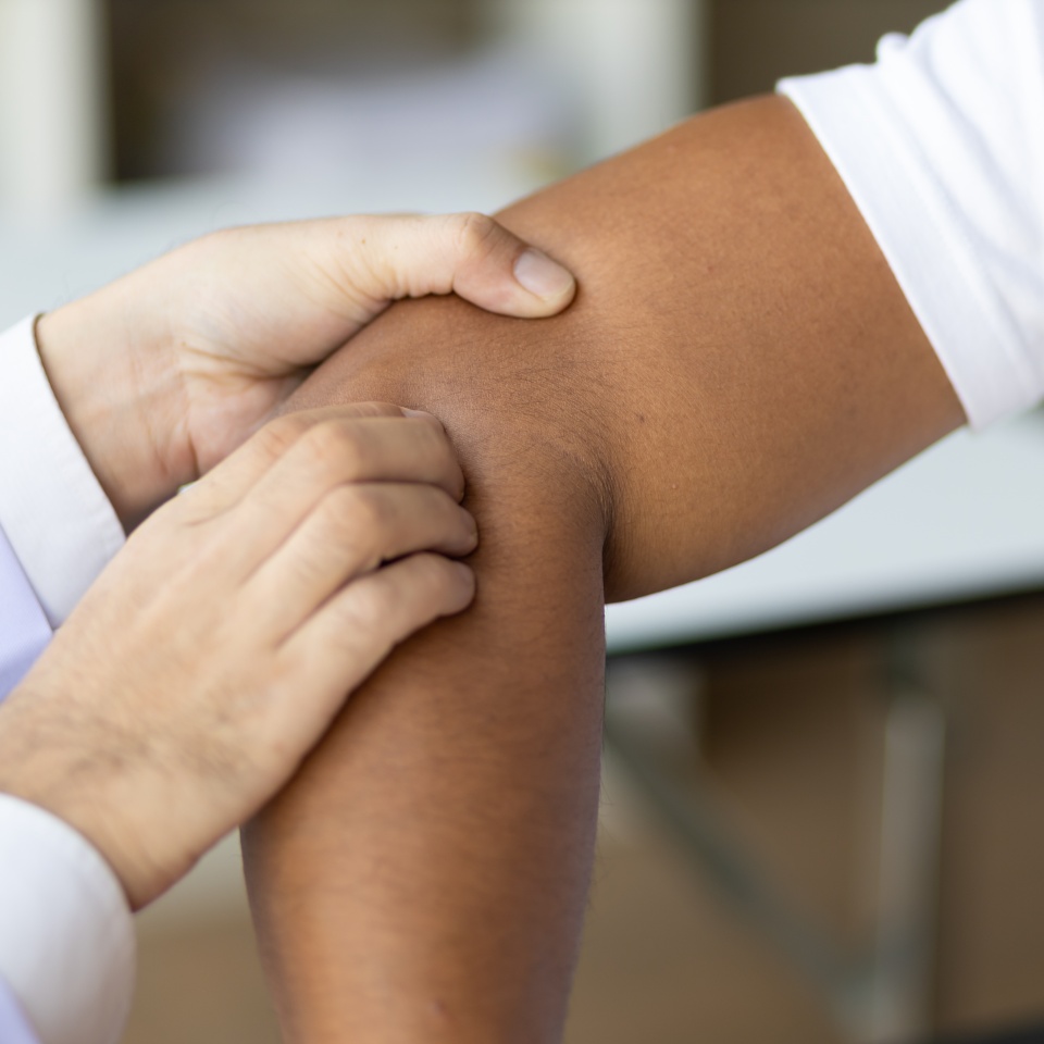 Man with arm pain, wrist pain and shoulder pain is seeing a doctor for diagnosis in an examination room at a hospital.
