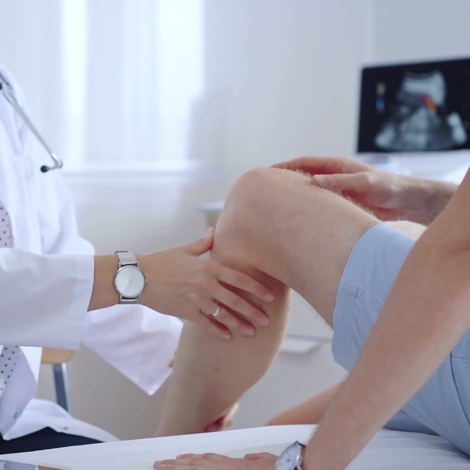 Doctor is carefully examining a patient's knee, providing personalized care and support. Medicine and orthopedic concept.