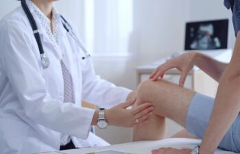 Doctor is carefully examining a patient's knee, providing personalized care and support. Medicine and orthopedic concept.
