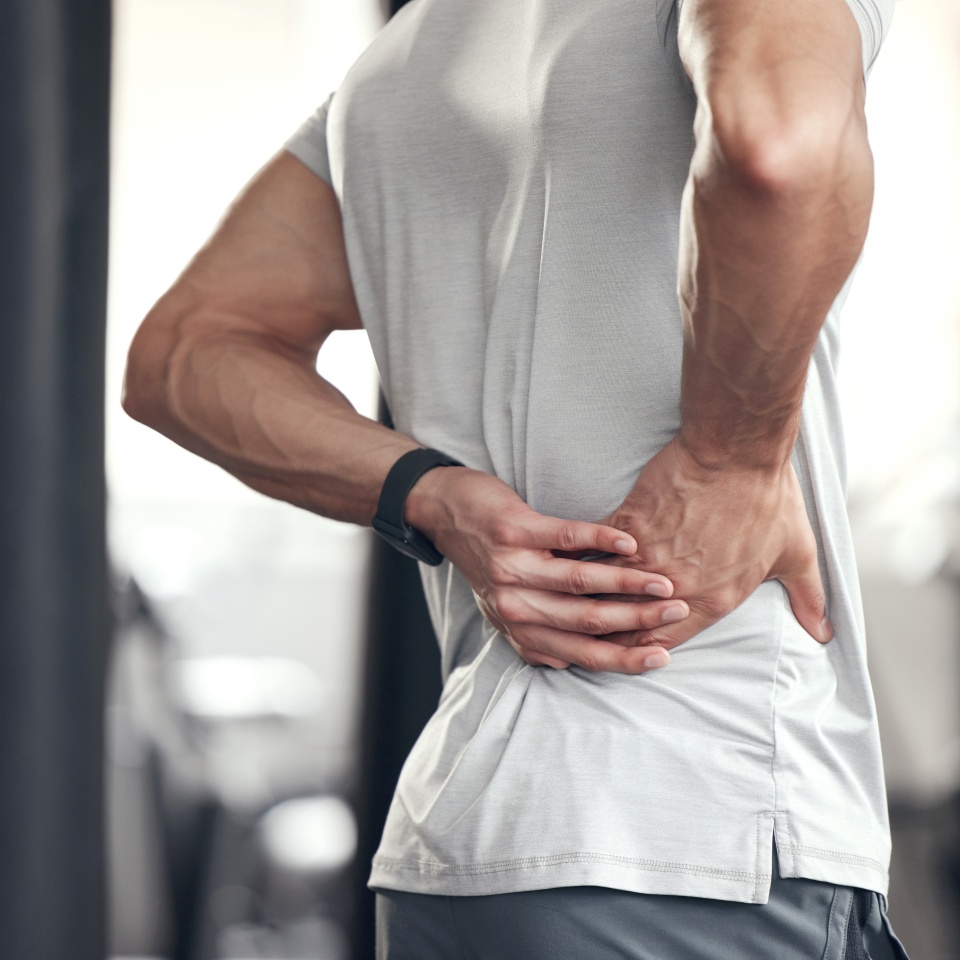 Hip pain, man and fitness injury at gym for boxing, sport and training with accident at health center. Wellness, hands and exercise of an athlete with hurt joint and scoliosis concern of spine.