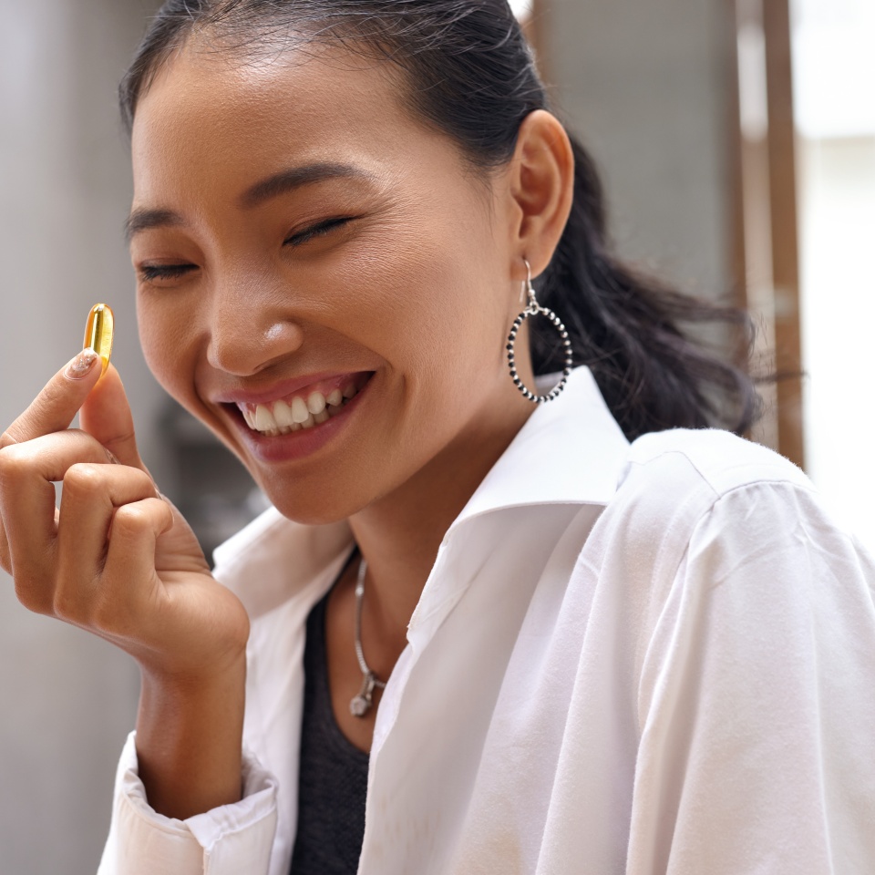 Diet. Nutrition. Healthy Eating, Lifestyle. Close Up Of Happy Smiling Woman Taking Pill With Cod Liver Oil Omega-3 In Morning. Vitamin D, E, A Fish Oil Capsules