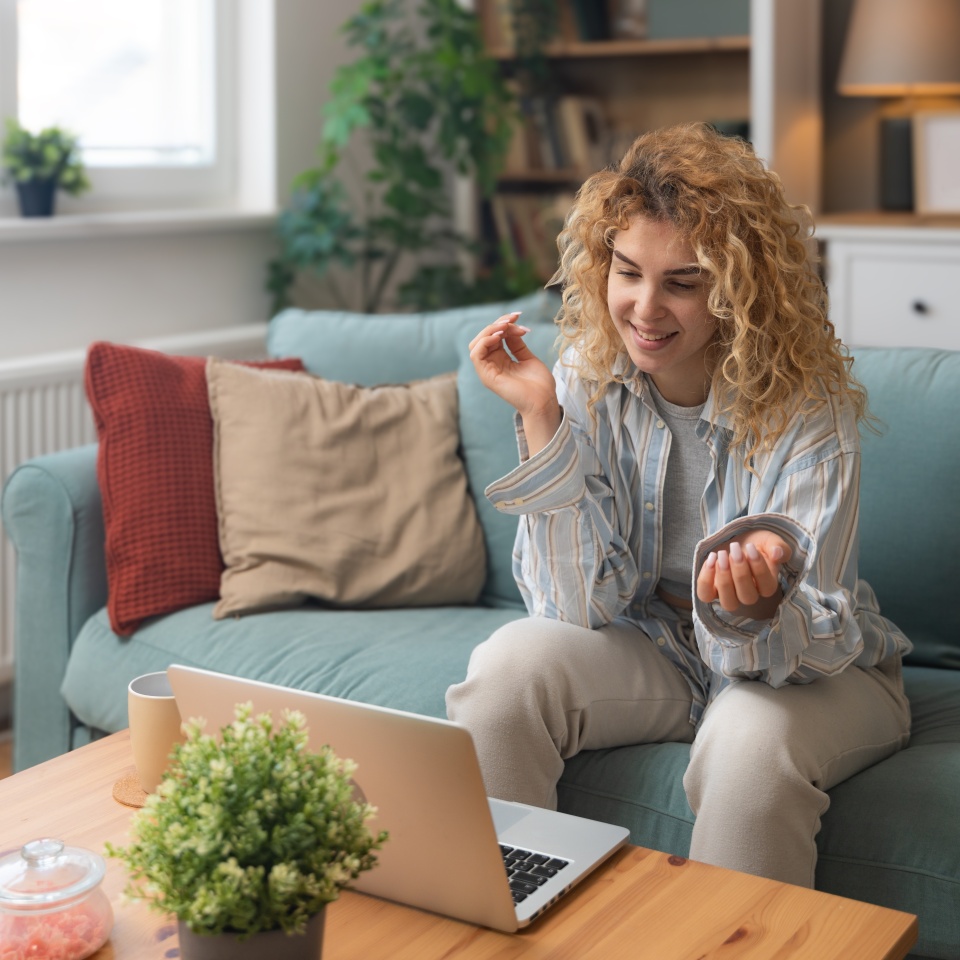Young woman talking on video call with her psychotherapist doctor after online therapy sessions, happy that she is well and mentally health now after telemedicine conversations. Thank you for help